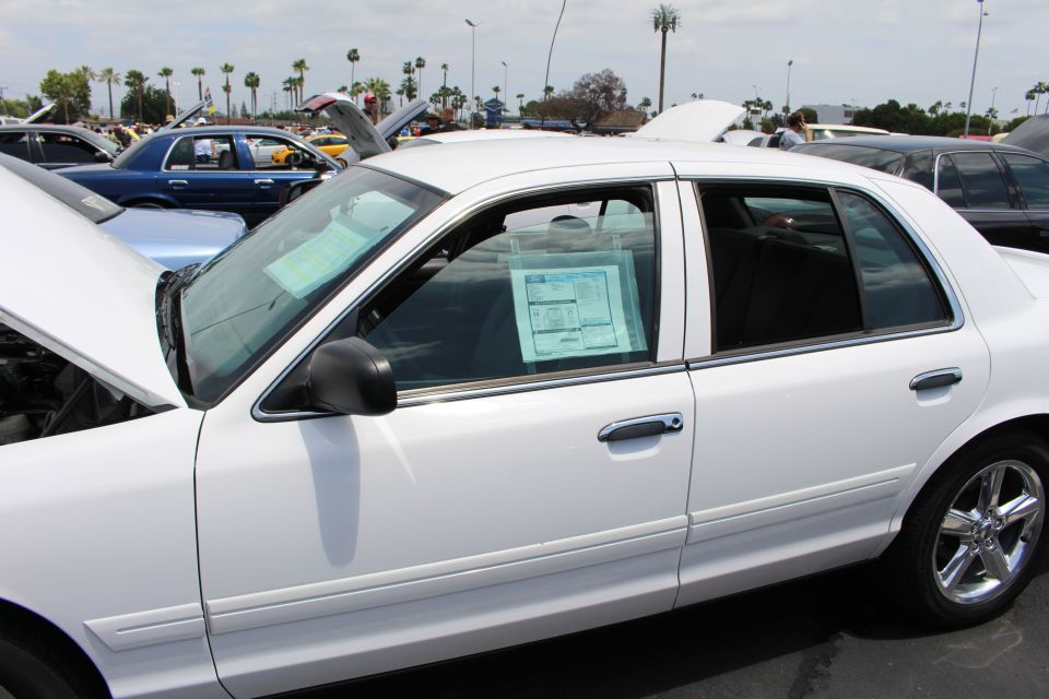 White sedan side profile with printed show display cards in the windows