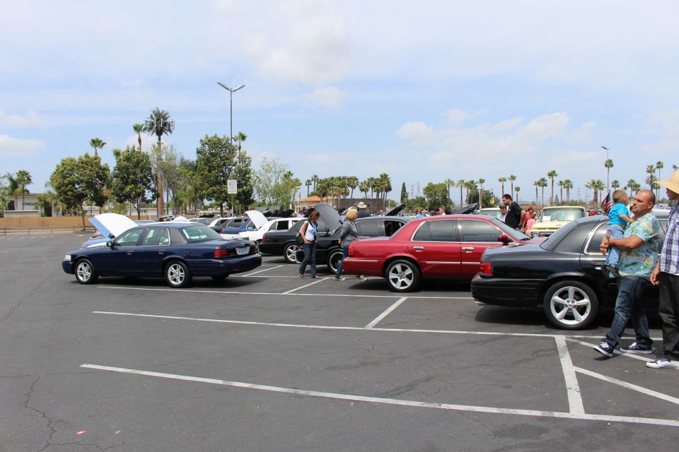 Blue, red and black full-size sedans parked in a row at a car show