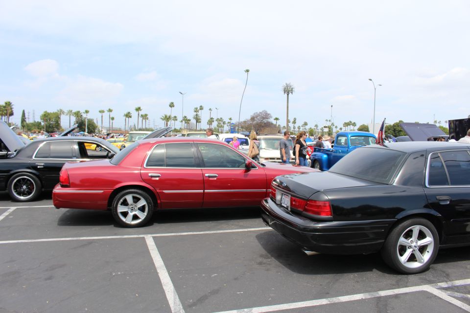 Maroon and black full-size sedans parked nose-to-tail at a car show