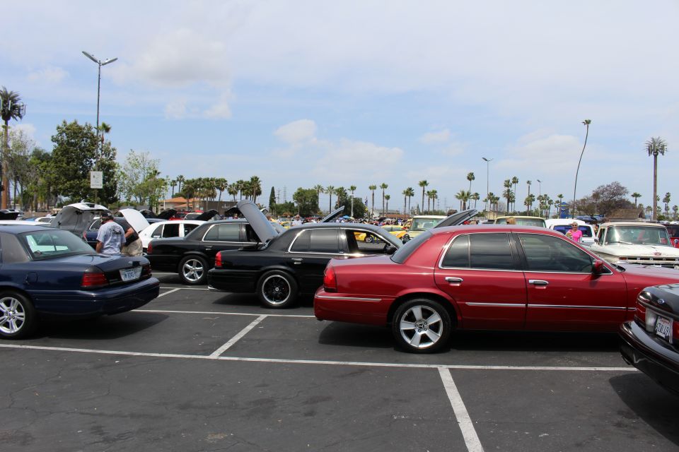 Blue, black and red full-size sedans parked at a car show