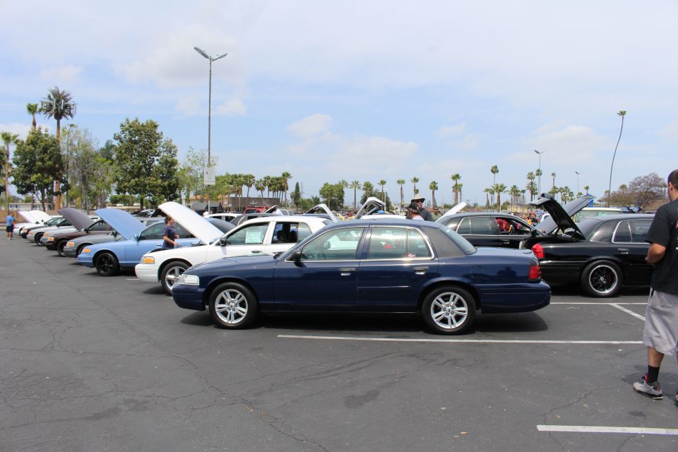 Dark blue full-size sedan parked among a row of show cars