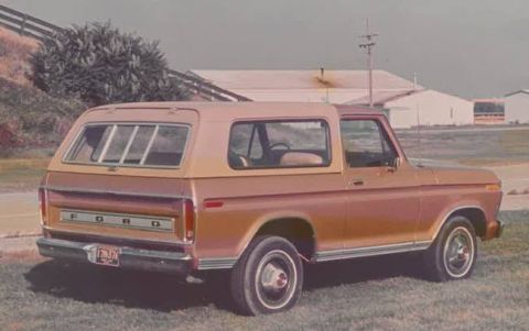 1988 Ford Bronco - This tan Ford Bronco is shown from the rear 3/4 angle, with the FORD badging visible on the tailgate.
