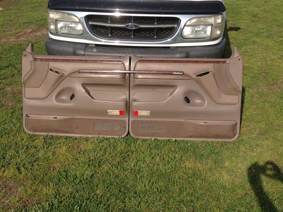 Front of a 1995 Ford Explorer with two tan door panels laid out in front of it on grass