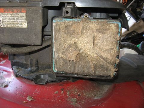 2006 Honda RANCHER - A very clogged air filter on a lawn mower, likely needing replacement.