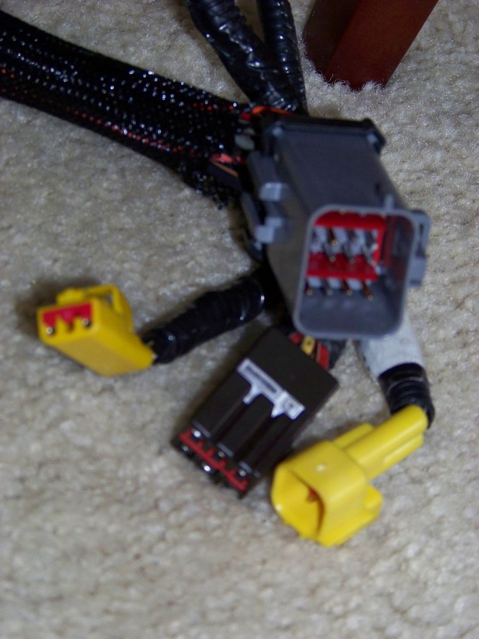 Close-up of automotive wiring harness with gray, black, and yellow connectors