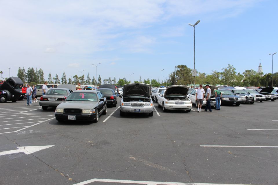 Two sedans facing camera with hoods open, people standing nearby