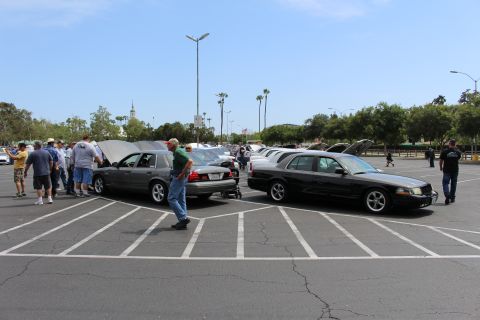 Gray and black sedans parked rear-to-rear, people walking nearby