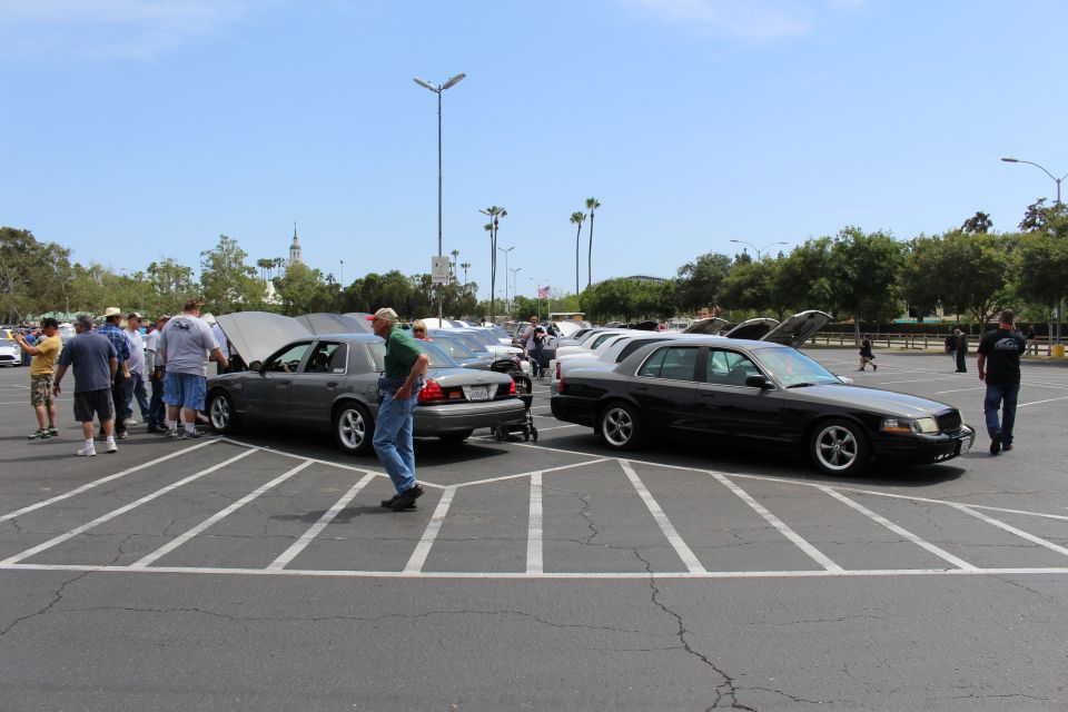 Gray and black sedans parked rear-to-rear, people walking nearby
