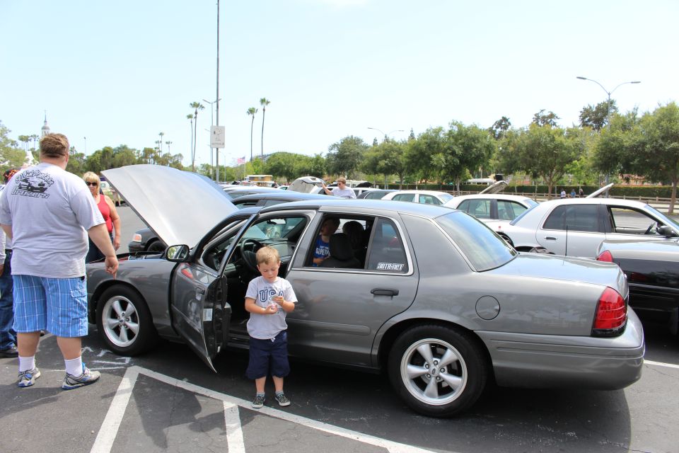 Gray sedan with hood up, a young boy standing by the open driver door