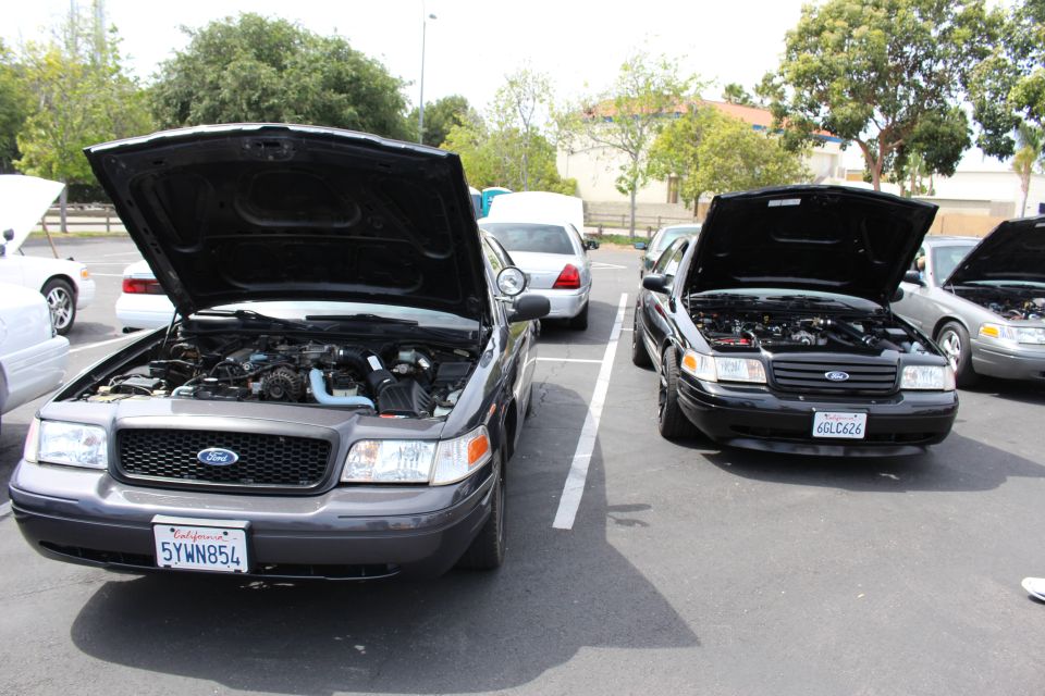 Two dark Ford sedans with raised hoods and visible California plates