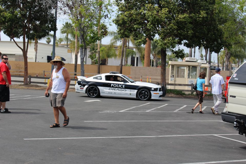 White and black Mustang-style coupe lettered POLICE driving in a lot