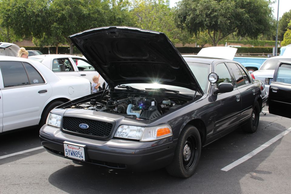 Dark gray Ford Crown Victoria with hood open showing engine bay