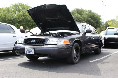 Dark gray Ford Crown Victoria with open hood and steelie wheels