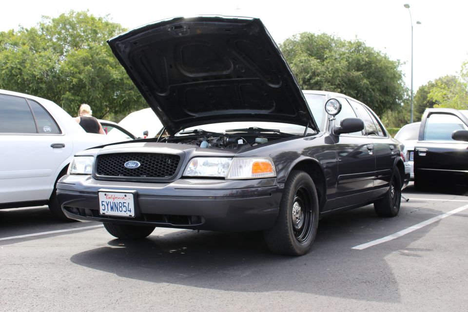 Dark gray Ford Crown Victoria with open hood and steelie wheels
