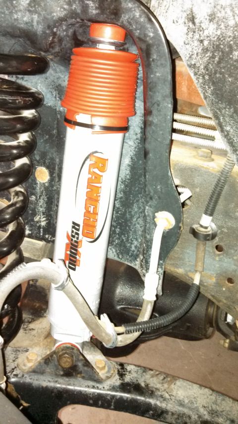 1996 Ford Bronco - Close-up of a Rancho RS5000 shock absorber with an orange dust boot, part of the suspension system.