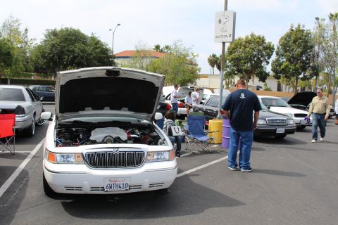 White Mercury Grand Marquis with open hood and waterfall grille at a meet