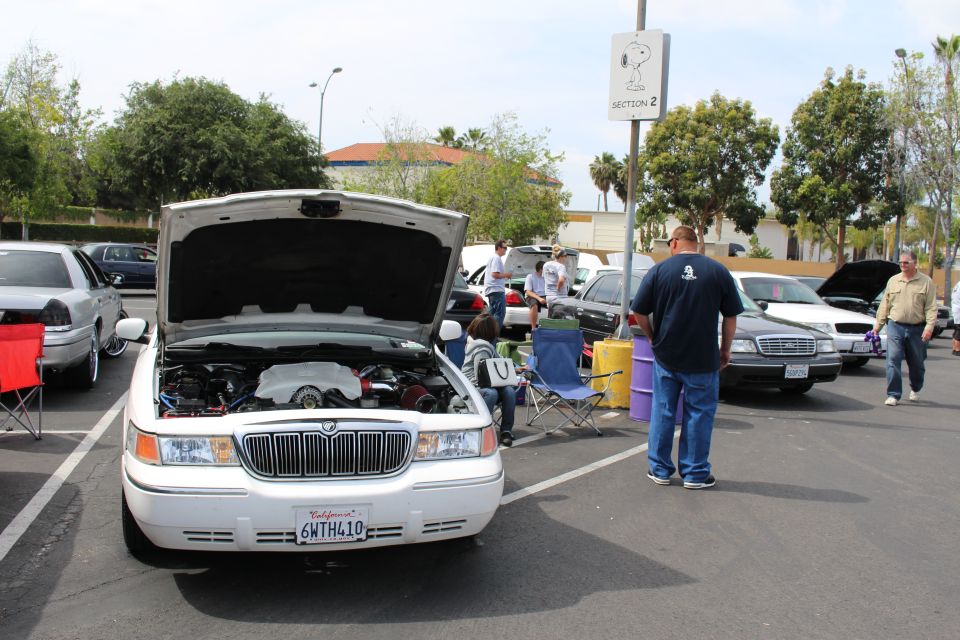 White Mercury Grand Marquis with open hood and waterfall grille at a meet