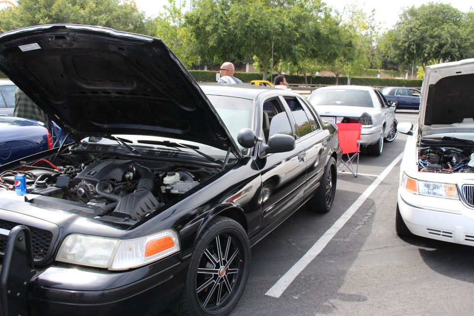 Black Ford Crown Victoria with open hood and black machined wheels