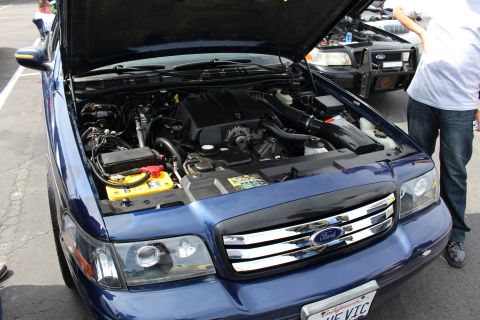 Blue Ford Crown Victoria with open hood and THE VIC plate