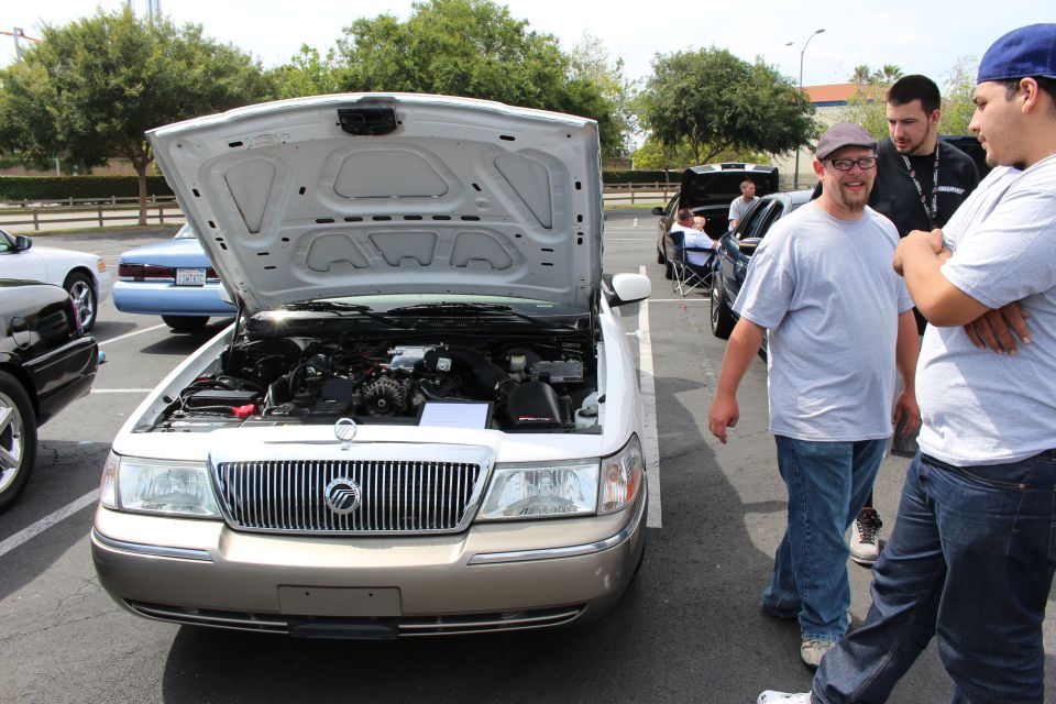 Silver Mercury Grand Marquis with open hood at a car show