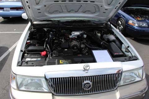 Engine bay of a silver Mercury sedan with chrome grille