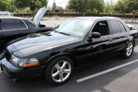 Black Mercury Marauder sedan with hood up at a parking-lot car show