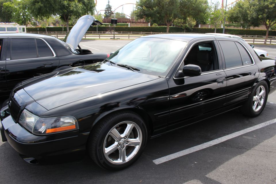Black Mercury Marauder sedan with hood up at a parking-lot car show