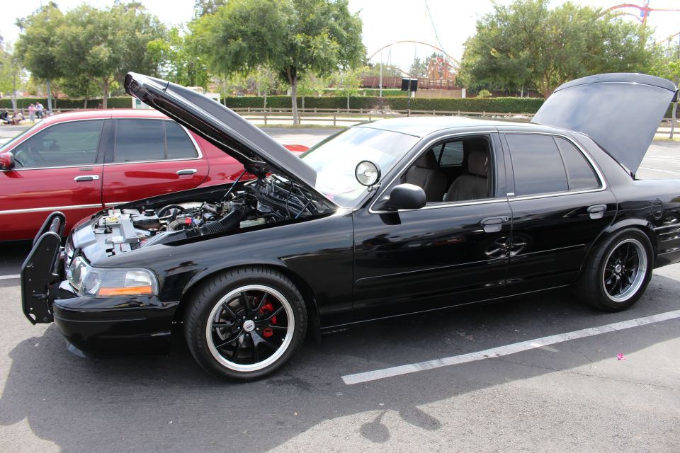 Black Mercury sedan, hood up, on black wheels in a show lineup
