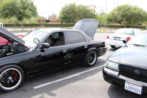 Two black Mercury sedans parked side by side with hoods up