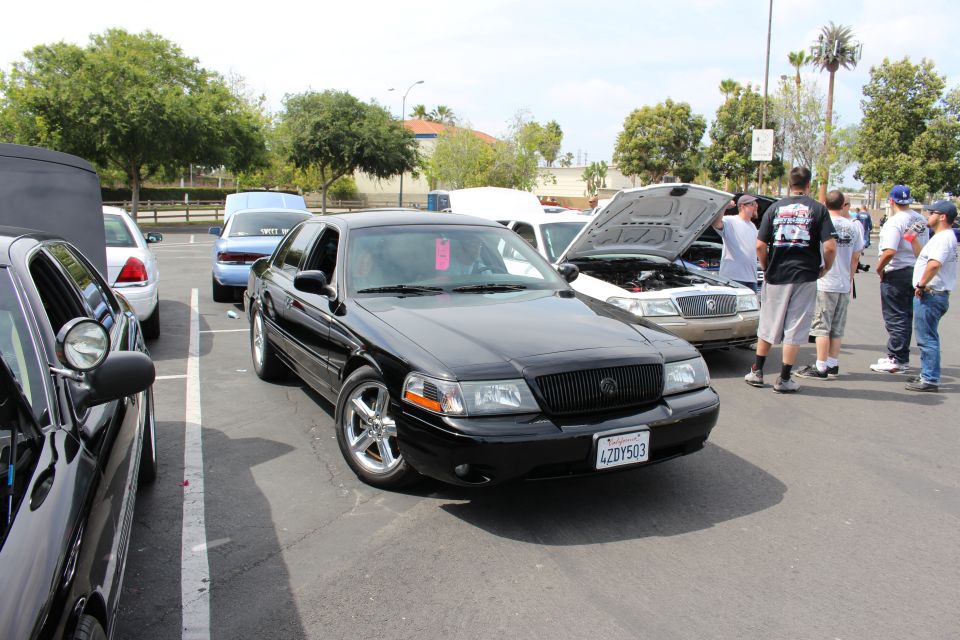 Black Mercury sedan, plate 4ZDY503, at a sunny car-show meet