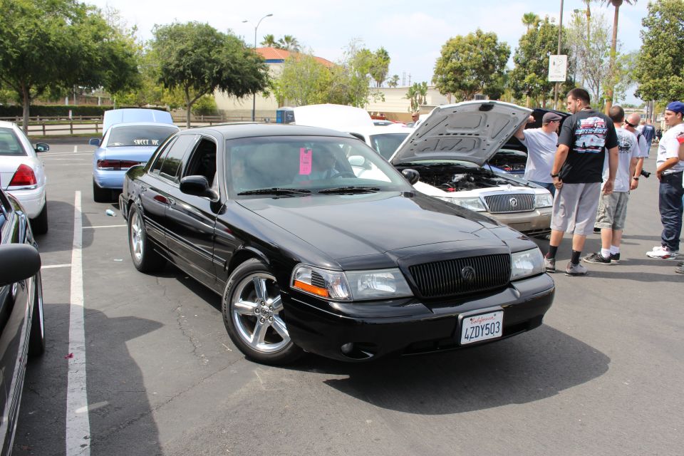 Black Mercury sedan with chrome wheels, plate 4ZDY503, at a meet