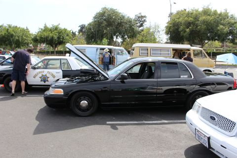 Black Ford Crown Victoria CHP-marked patrol cars at a car show