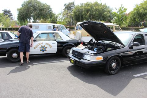 CHP cruiser and a black Ford Crown Victoria with open hood
