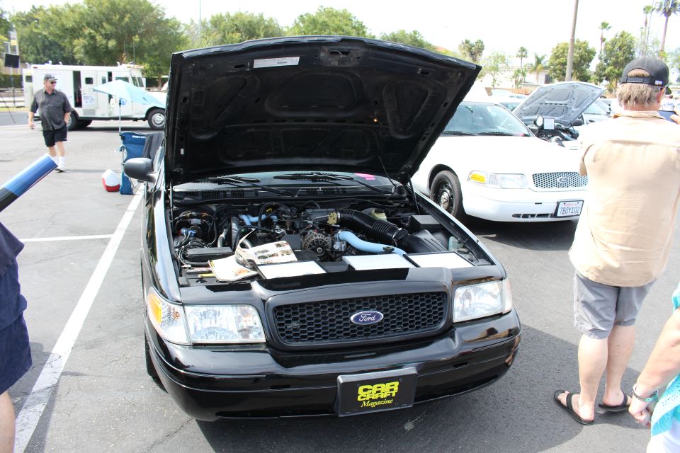 Black Ford sedan engine bay with Car Magazine plate, hood raised