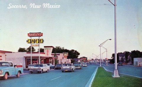 1991 Ford LTD Crown Victoria - A white and red 1959 Ford Fairlane 500 Skyliner cruises down a street in Socorro, New Mexico, past Shirley's Cafe.