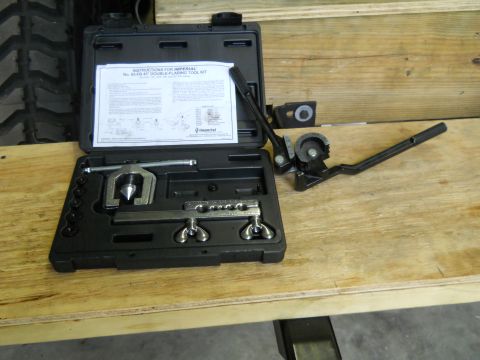1992 Ford Bronco - A double flaring tool kit is laid out on a wooden surface, with instructions and a tire visible in the background.