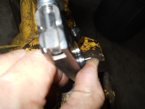 1992 Ford Bronco - A close-up shows a hand gripping a tool against a weathered, yellow surface.
