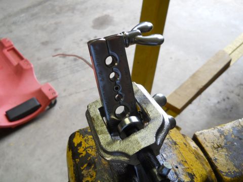 1992 Ford Bronco - A flaring tool is clamped in a vise, ready for use on a workbench.