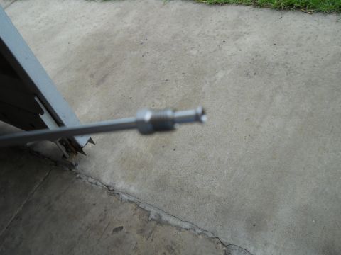 1992 Ford Bronco - Close-up of a metal cable end with a threaded fitting, likely a part from a vehicle or equipment.
