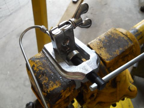 1992 Ford Bronco - A flaring tool is secured in a vise, ready for use on a metal tube.