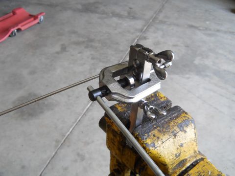 1992 Ford Bronco - A flaring tool is secured in a vise, preparing to shape metal tubing.