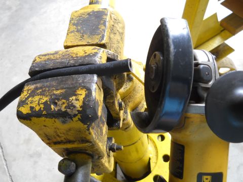 1992 Ford Bronco - A hose is secured in a vise, ready for cutting with an angle grinder. Text on the hose indicates it was manufactured in the USA.