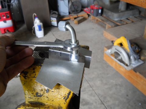 1992 Ford Bronco - A wrench is used to tighten a metal fitting secured in a vise.