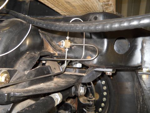 1992 Ford Bronco - Close-up of brake lines and suspension parts on a vehicle's undercarriage, a Supermotors.net watermark.