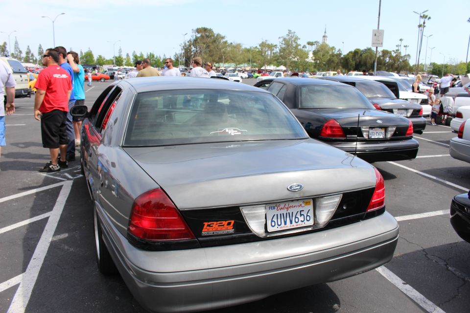 Rear of a silver Ford Crown Victoria sedan with California plate at a parking-lot car meet