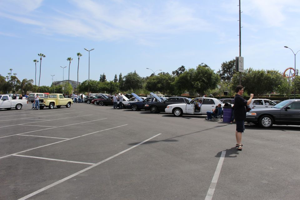 Wide view of a parking-lot car show with sedans and a vintage pickup truck