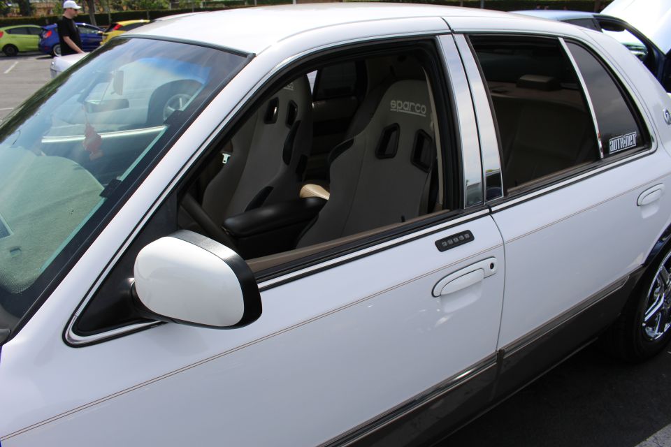 View through sedan windows showing gray Sparco bucket racing seats in the interior