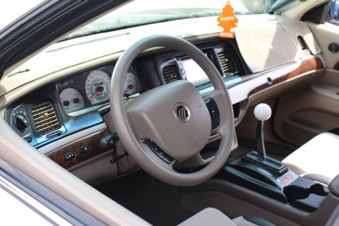 Mercury steering wheel and tan dash with a white-ball shifter on the console