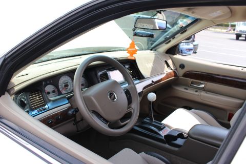 Interior of a Mercury sedan with tan dash, wood trim and white-ball shifter
