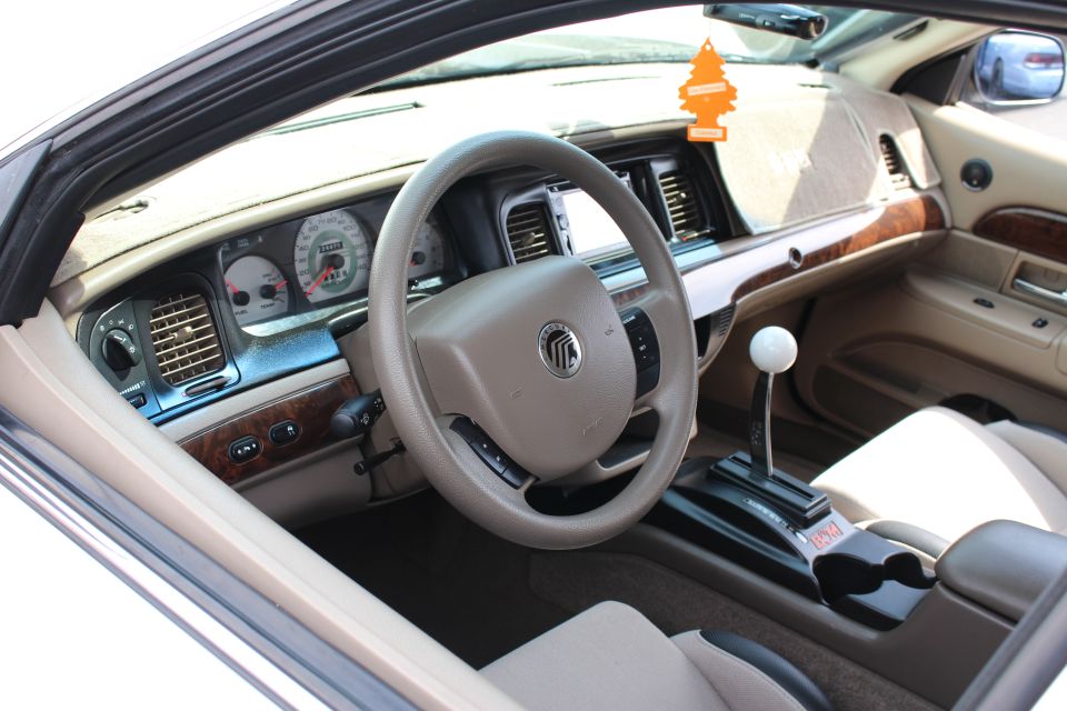 Mercury sedan interior with tan dash, wood trim and white cue-ball shifter